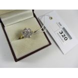 Seven stone diamond ring in flower head setting hallmarked 18ct