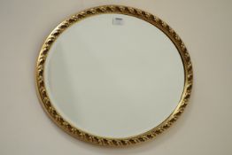 Small oval bevelled edge wall mirror in ornate gilt frame,