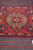 Tribal Balochi red and blue ground rug,