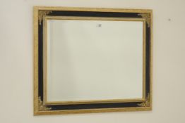 Bevelled edge mirror in black and gilt frame,