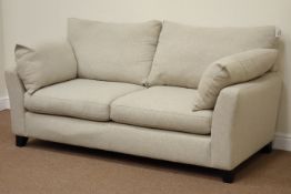 Next two seat sofa upholstered in beige cover, raised on ebonised feet,