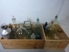 Bell shaped cloche with stopper and other vintage clear and coloured glass bottles in two wooden