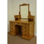 Edwardian light oak kneehole dressing chest fitted with nine drawers,