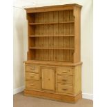 Traditional pine dresser fitted with central cupboard with a series of three drawers either side