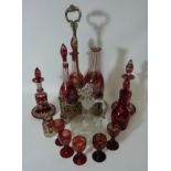 Late Victorian silver-plated three bottle holder containing three similar ruby overlaid glass