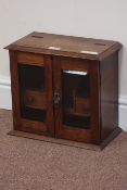 Early 20th century oak smokers cabinet, fitted interior, enclosed by two bevelled glass doors,