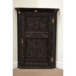Victorian oak corner cabinet enclosed by single door heavily carved with floral decoration,