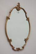 Shaped ornate gilt framed bevel edged mirror,