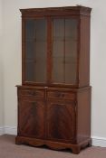 Reproduction mahogany bookcase enclosed by two doors on double cupboard fitted with two drawers,