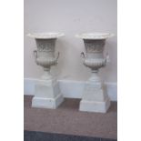 Pair Victorian style urns on plinths, egg and dart rim decoration, lion mask handles,