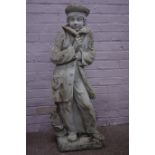 Large composite stone garden figure of a boy wearing winter coat,