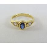 Gold rub over oval Sapphire and Diamond three stone ring hallmarked 18ct Condition Report