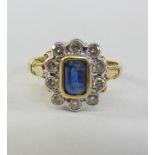 Gold cluster ring set with an emerald cut sapphire and ten diamonds hallmarked 18ct