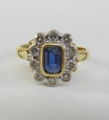 Gold cluster ring set with an emerald cut sapphire and ten diamonds hallmarked 18ct