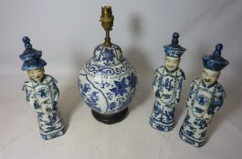 Three Chinese scholars and a Chinese blue and white lamp base with wooden stand