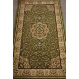 Keshan style rug, central medallion over green ground, cream boarder,
