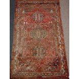 Kashcia carpet with triple central medallions over red ground decorated with birds and flowers,