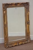 Ornate swept gilt framed bevel edged mirror,
