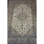 Kashan carpet with central rosette, over cream ground allover floral decoration, spandrels,