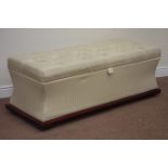 Large upholstered ottoman with hinged lid, mahogany finish plinth, fitted with castors, W138cm,