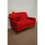 Two seat sofa upholstered in red fabric, raised on tapering feet,