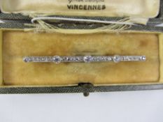 Diamond platinum set bar brooch comprising five diamonds graduating to left and right interspersed