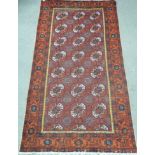 Afghan long carpet with three rows of seven guls, over red ground triple floral boarders,