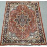 Heriz Indo Persian carpet, with central rosette over red ground, floral design, spandrels,