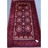 Persian Baluchi red ground rug, repeating gull design, with purple elements,