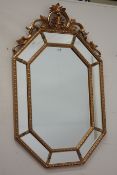 Gilt framed octagonal pier glass mirror, fitted with bevelled glass, Florentine style pediment,
