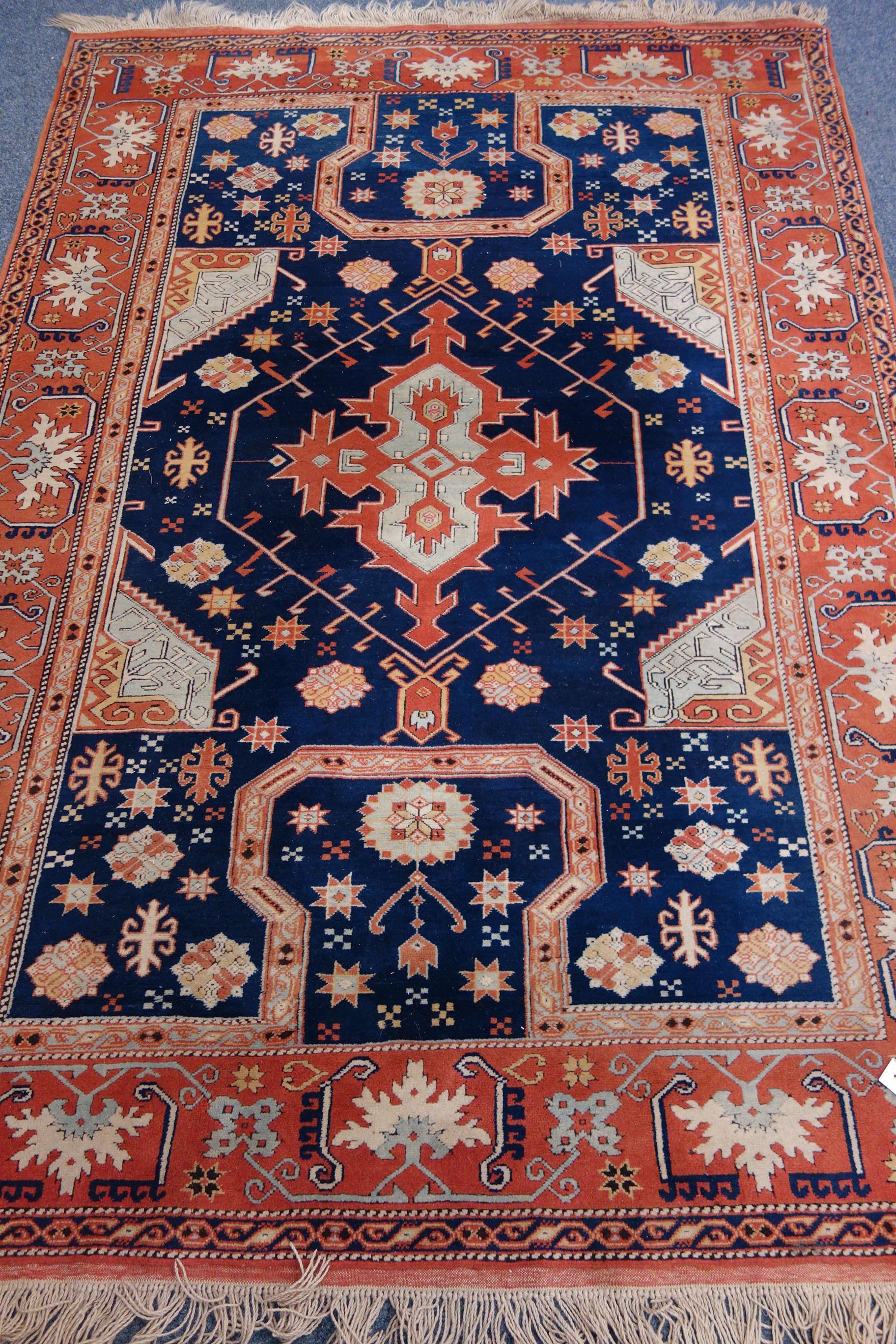 Persian red and blue ground rug, overall geometric design, with stylized motifs,