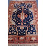 Persian red and blue ground rug, overall geometric design, with stylized motifs,