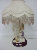 Italian figural lamp of a young woman playing the harp, with beaded shade,