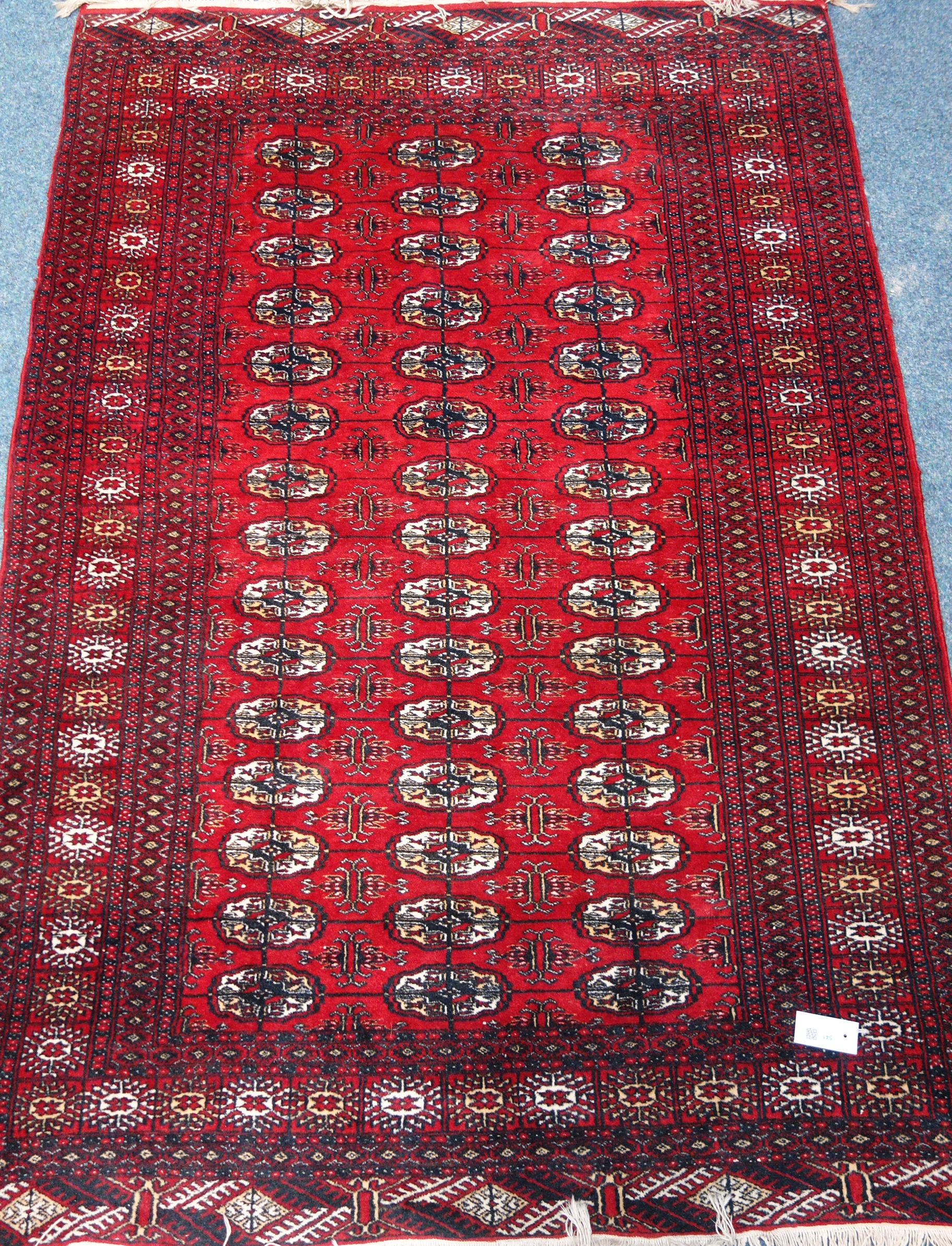 Persian Bokhara design red ground rug,