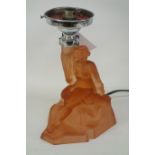 A rose coloured lamp base in the form a young lady in flowing dress seated on rock holding lantern