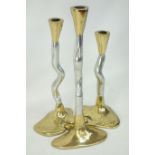 Three graduated brass and steel contemporary candle sticks,