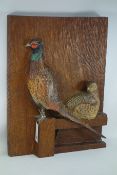 Oak adzed deep carved plaque depicting a cock and hen pheasants,