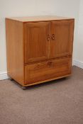 Ercol light elm tallboy cabinet, enclosed by two doors, with fall front compartment below, W85cm,