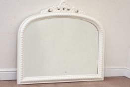 White painted over mantle mirror, floral pediment over beaded moulded arched frame,