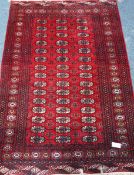 Persian Bokhara design red ground rug,