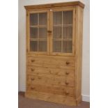 Waxed pine display cabinet enclosed by two glazed doors above four long drawers, W113cm, H183cm,