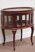 20th century oval mahogany bevel glass glazed bijouterie cabinet enclosed by two doors,