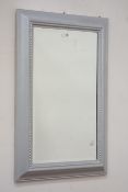Moulded silver framed mirror fitted with bevelled glass,