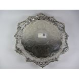 Silver salver raised on three ball and claw feet with fretwork border and bright cut decoration by