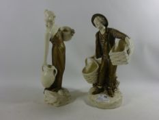 Amphora type porcelain figures of a male holding wicker baskets and a lady holding water jugs (2)