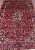 Persian Bijar hand knotted red ground rug, repeating herati motif field,