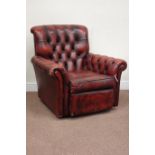 Traditional armchair upholstered in deeply buttoned vintage red leather,