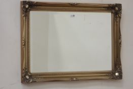 Gilt framed wall mirror fitted with bevelled glass,