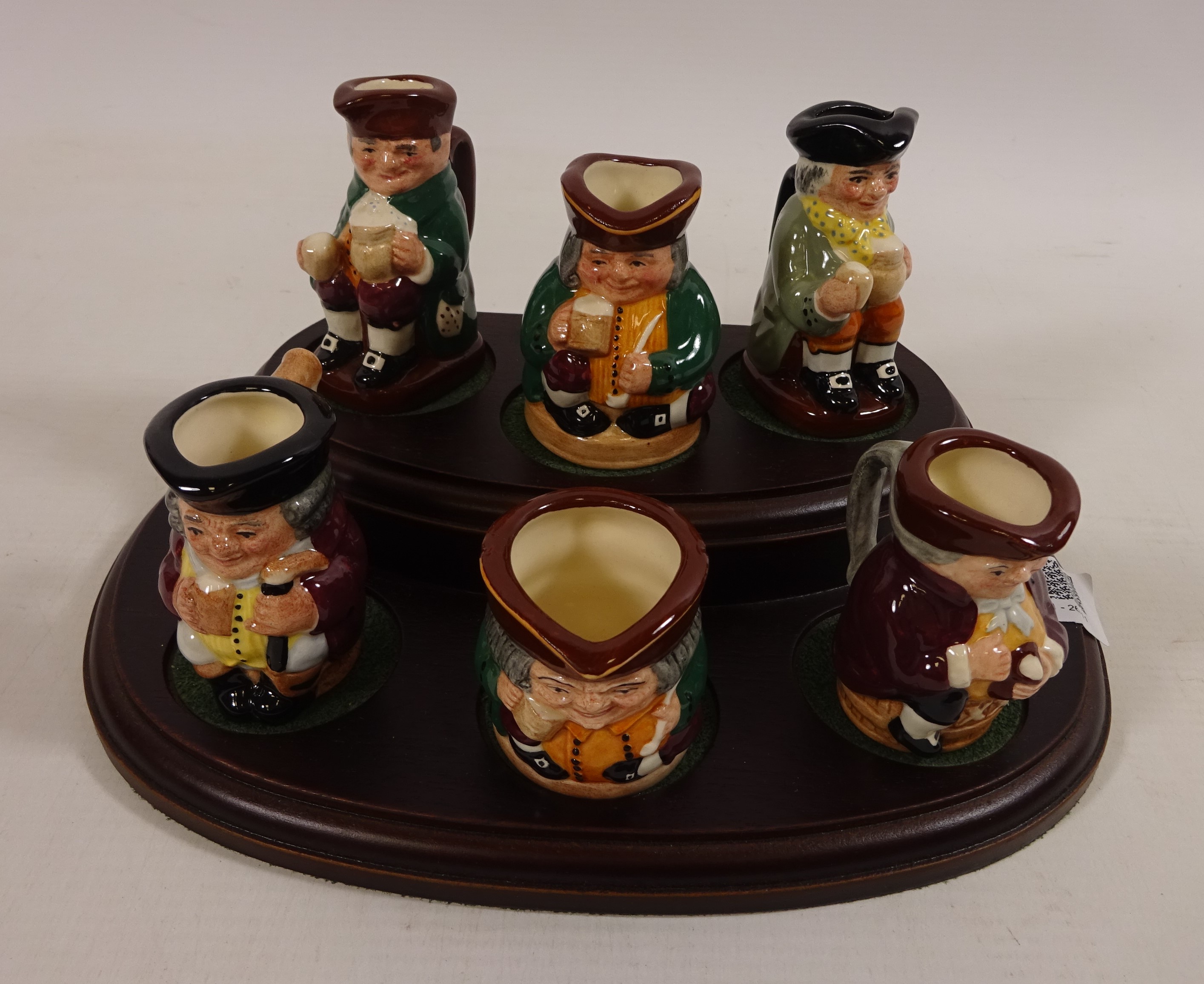 A collection of six miniature Royal Doulton Toby jugs on stand Condition Report