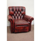 Traditional armchair upholstered in deeply buttoned vintage red leather,